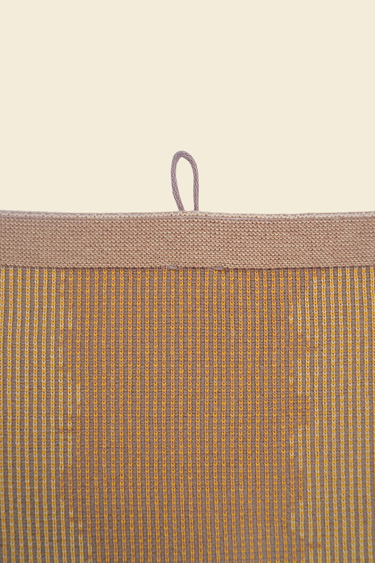 top detail of yellow knit organic cotton kitchen towel with wavy pattern
