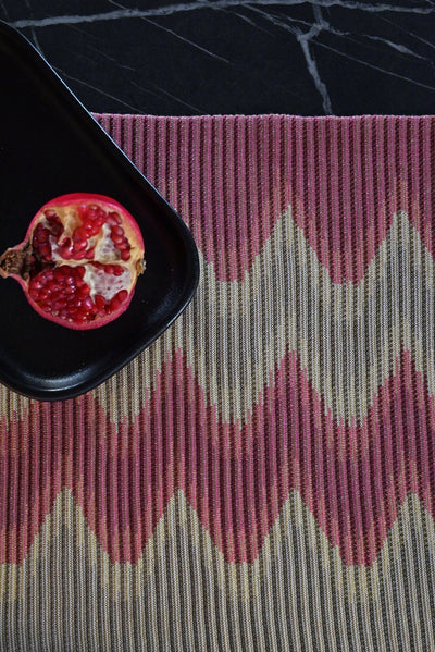 top detail of red/gold knit table mat in organic cotton and viscose with wavy pattern