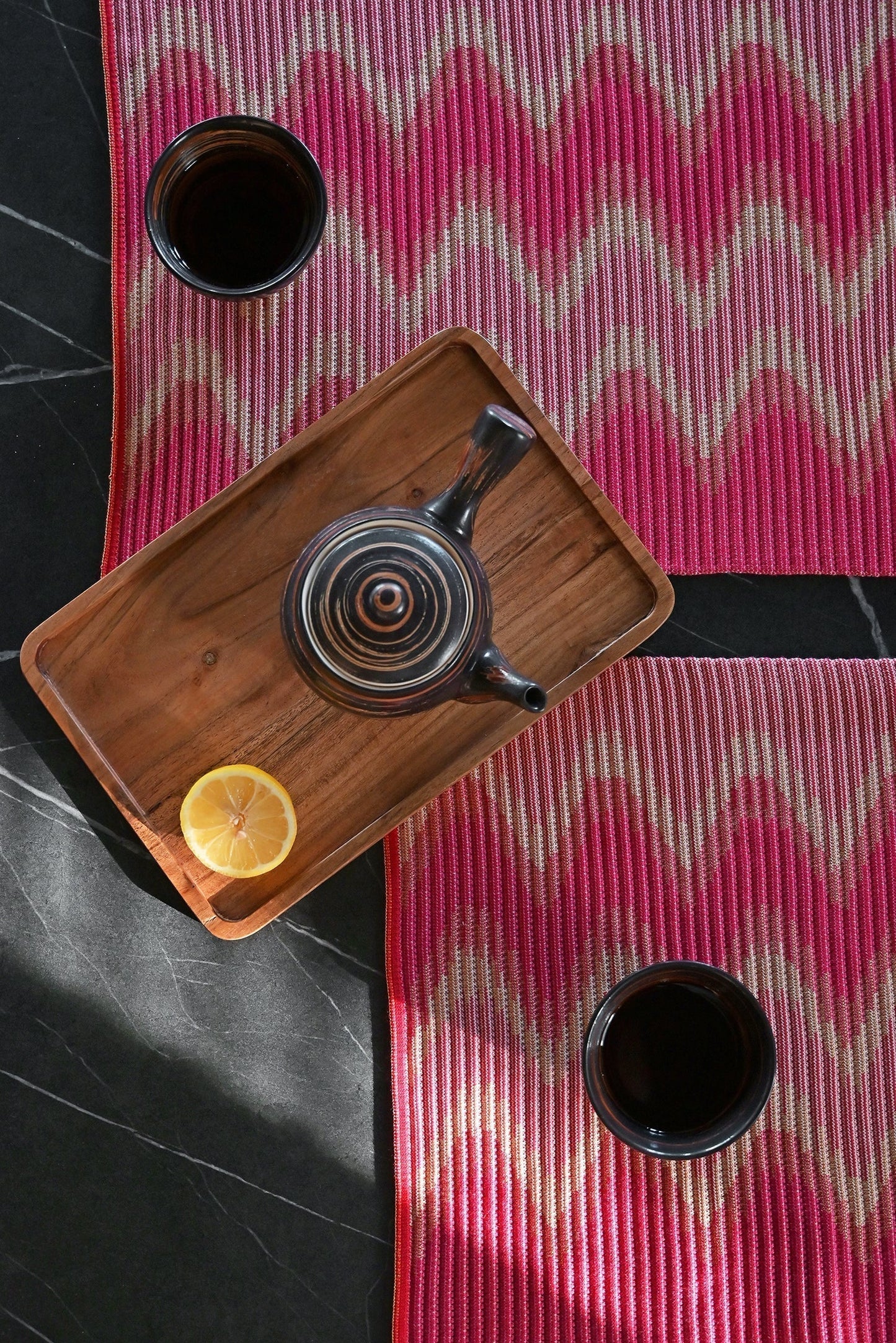 top detail view of red/yellow knit table mat in organic cotton and viscose with wavy pattern