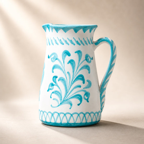 White ceramic pitcher with blue floral patterns on a beige background