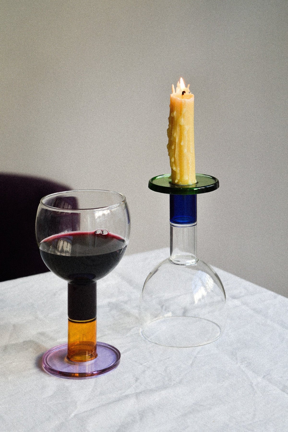 Bifunctional wine candle glasses with red wine and a lit candle on a table, showcasing taverna-style design.