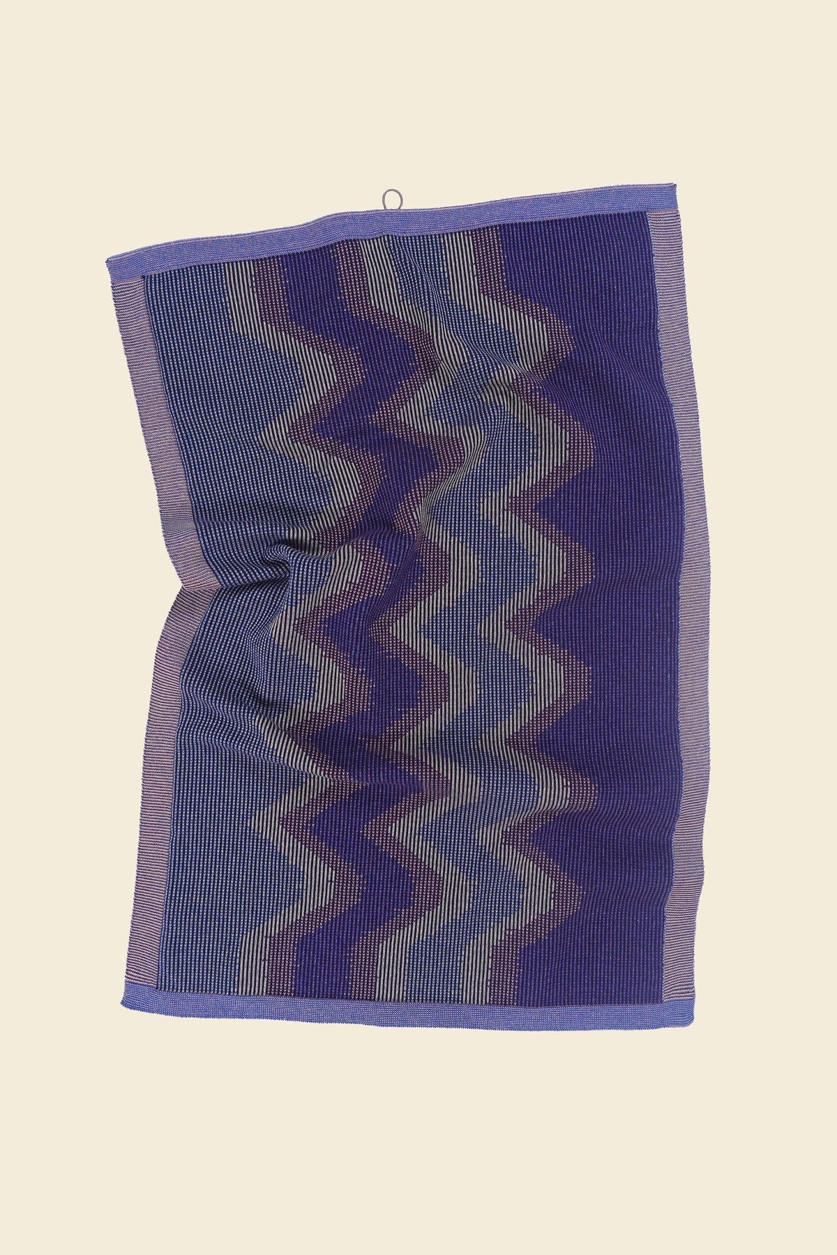 top view of purple knit organic cotton kitchen towel with zig zag pattern