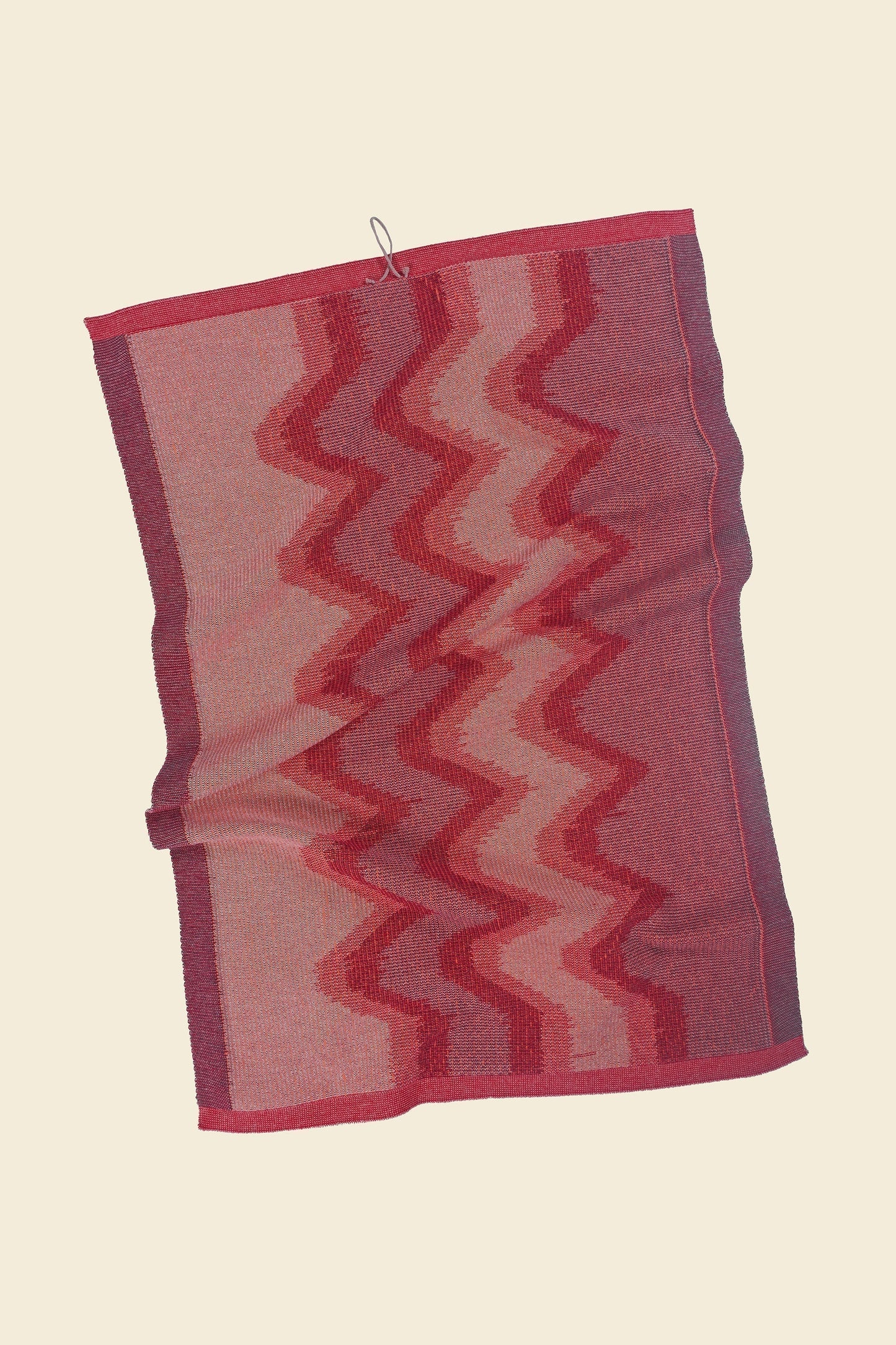 back side of red knit organic cotton kitchen towel with zig zag pattern