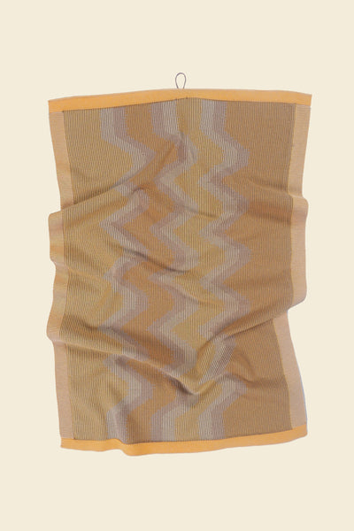front view of yellow knit organic cotton kitchen towel with zig zag pattern with folds