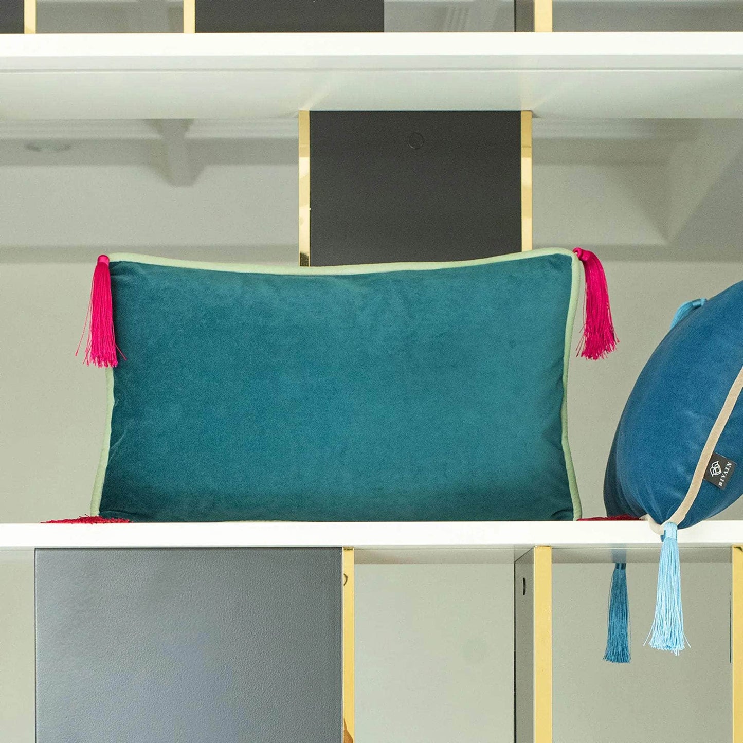 Teal velvet rectangular cushion with mint piping and fuschia tassels